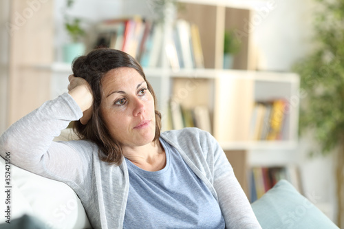 Pensive adult woman thinking looking away at home photo
