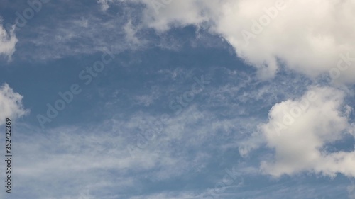 Clear blue sky with cumulus clouds that stand still and cirrus clouds that float. Joyful mood. High pressure and difference in movement in the atmosphere. Ecology of clean air. Weather forecast