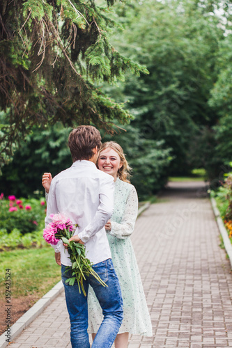 A man gives his beloved, girl flowers, peonies, Declaration of love, proposal, marriage, meeting, date, kisses, summer, walk, bouquet