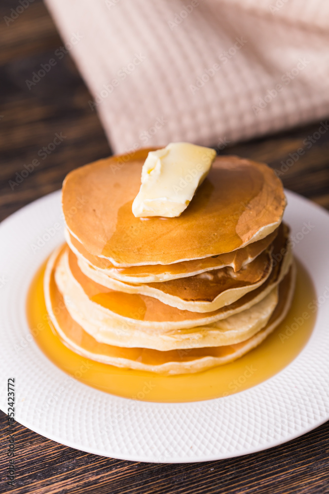 Golden pancakes with butter and warm maple syrup. Golden pancakes with butter and warm maple syrup.
