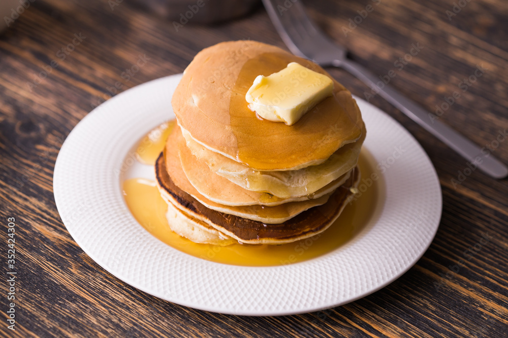 Golden pancakes with butter and warm maple syrup. Golden pancakes with butter and warm maple syrup.