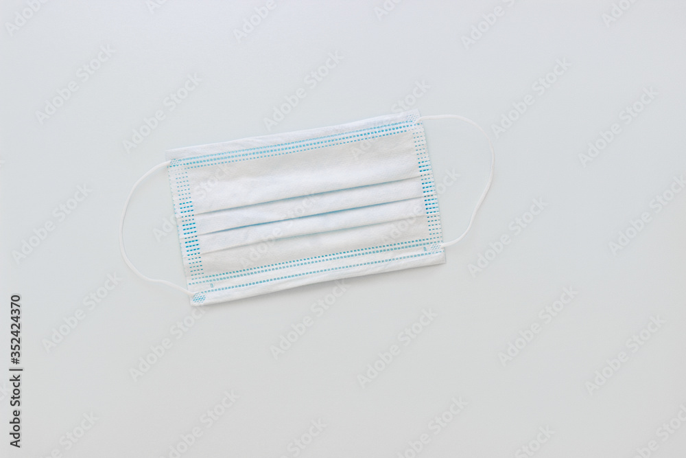 White medical mask to protect your health from the virus on a white-grey background White medical mask to protect your health from the virus on a white-grey background