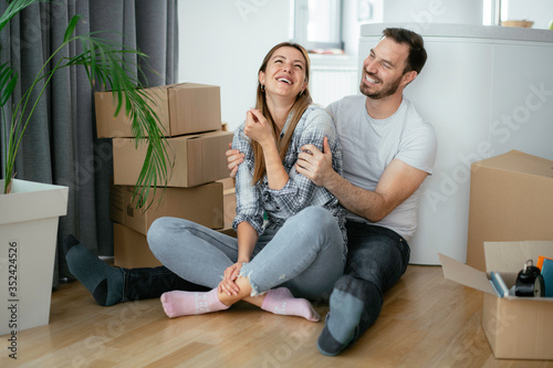 Husband and wife are moving in a apartment. Husband and wife are unpacking their belongins.	 photo