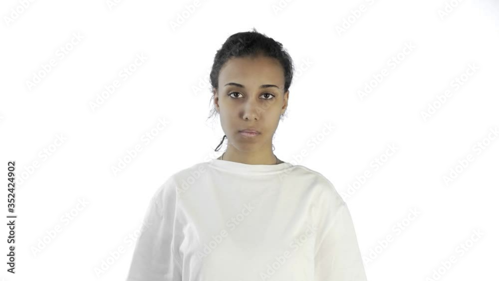 Beautiful young girl in a white T-shirt shows thumb down with both hands on white background Beautiful young girl in a white T-shirt shows thumb down with both hands on white background