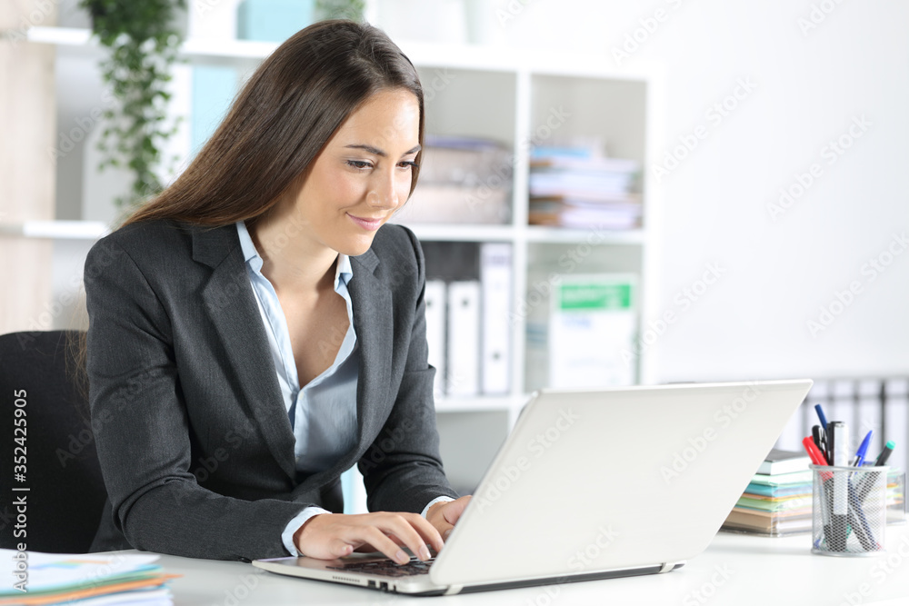 Executive woman typing on laptop sitting at the office Executive woman typing on laptop sitting at the office