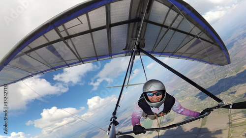 Female hangglider pilot high in the sky