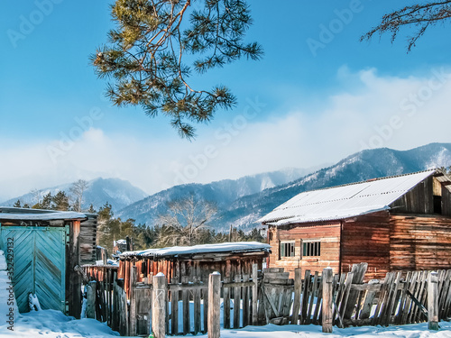 Village at the foot of the mountains in winter, winter background