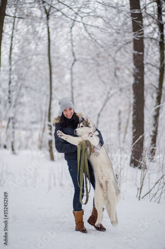 woman with husky dog in winter in the snow