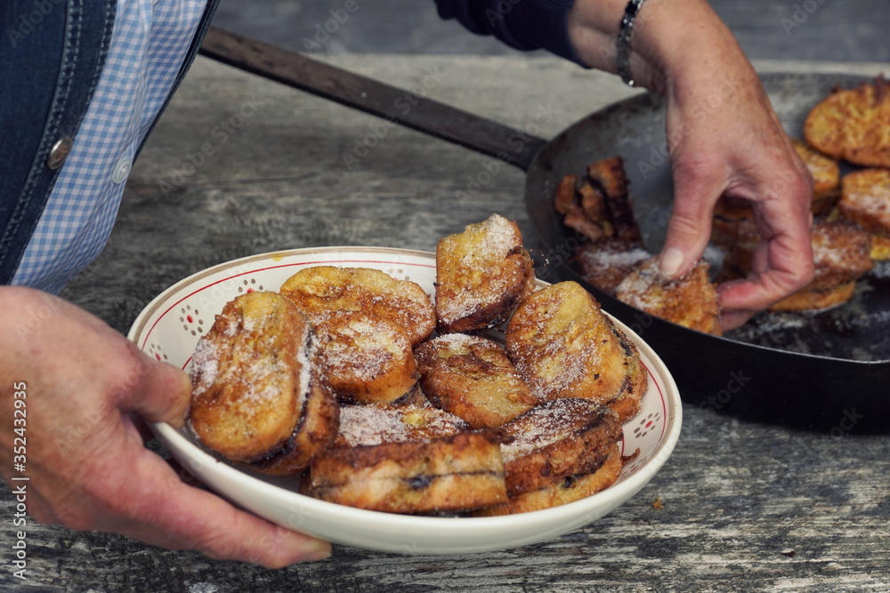 Obraz premium Traditional Austrian desert „Pofesen“ (french toast with sugar and plum jam) served in an iron pan on an alpine hut