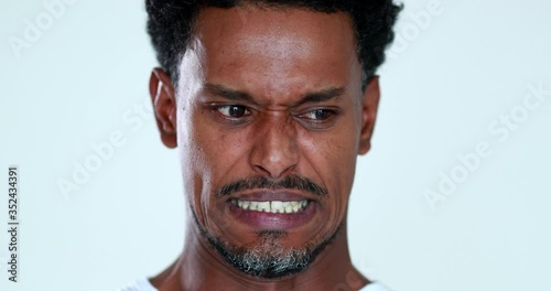 Person feeling disgust emotion portrait face close-up. African black man disliking