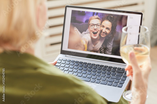 Two happy women on computer monitor talking online with their friend who sitting at home