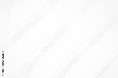 White fabric cloth background abstract with soft waves , flowing draped cloth in rippled elegant curves and wrinkled creases , soft focus, textured background and abstract