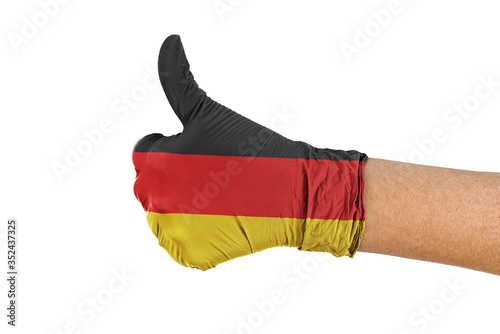 Germany flag on a medical glove showing thumbs up sign