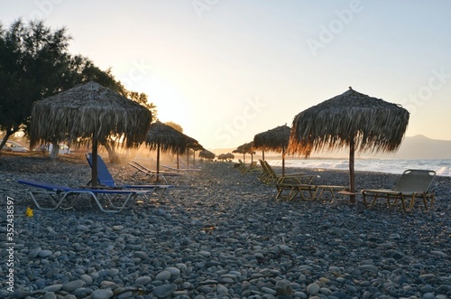 Grass beach umbrellas sunset in Greece