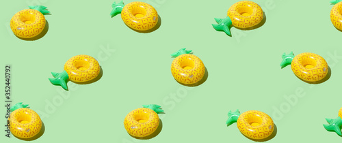 Fototapeta Naklejka Na Ścianę i Meble -  Yellow inflatable pineapples on a green background