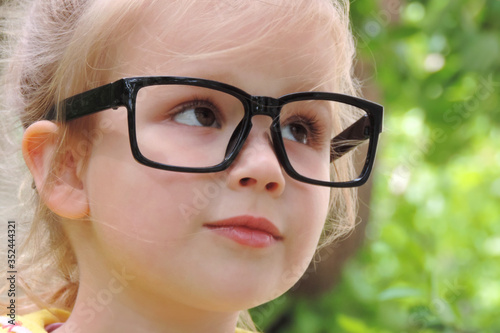 girl's face with glasses a black frame © ElenaEmiliya