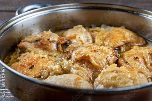 Chicken thighs fried in a pan, close-up, shallow depth of field, selective focus. Homemade food concept.