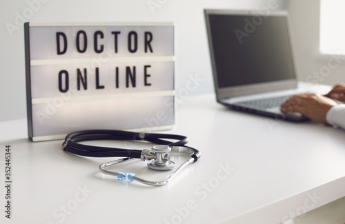 Doctor online. Online doctor typing message diagnoses analyzes prescription using laptop gadget webcam video conference in clinic office.