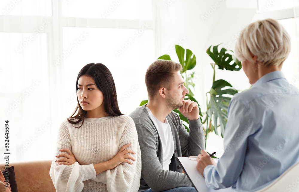 Counselor Talking To Unhappy Spouses During Therapy Session In Office Counselor Talking To Unhappy Spouses During Therapy Session In Office