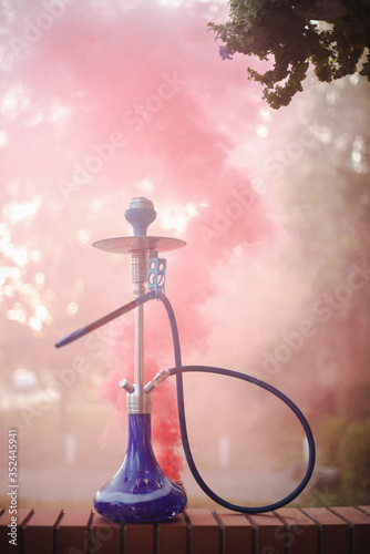 Hookah outdoors on a background of colored smoke