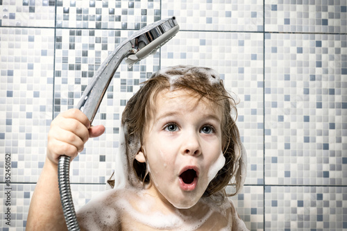 a child of 4 years old is covered in foam in a bathtub in his hand, holds a shower and screams emotionally, there is no water. the child can not wash off the soap, water pipe breakage.
