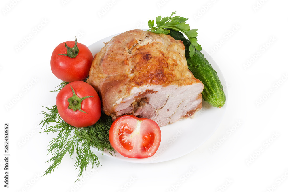 Baked pork shoulder among the vegetables on dish, top view