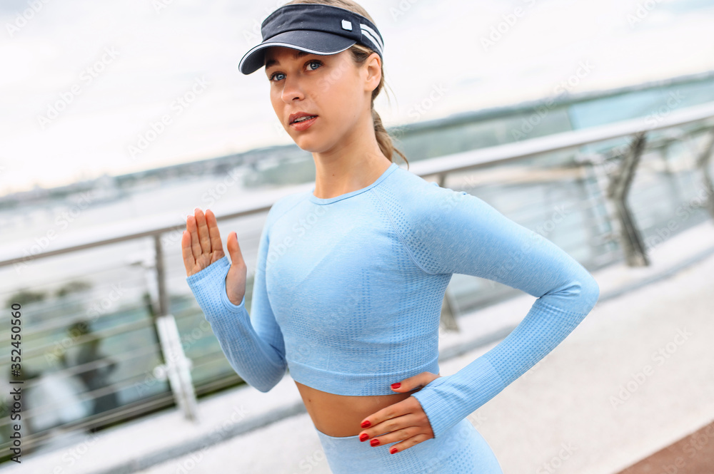 Morning jogging in the city. An athletic attractive woman in sportswear runs outdoors. Self discipline and healthy lifestyle concept