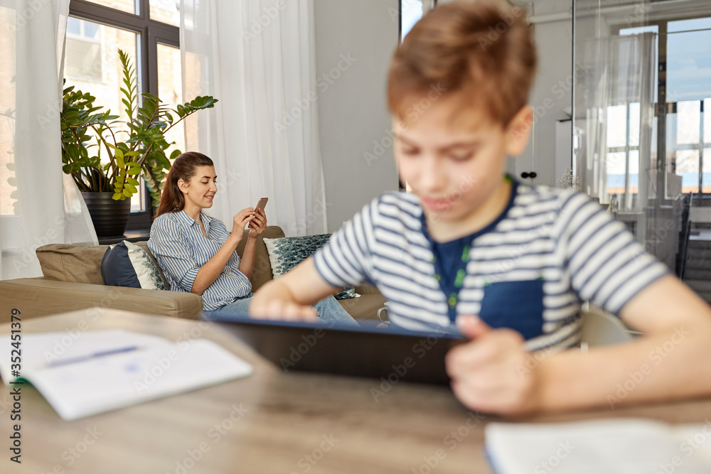 family, leisure and lifestyle concept - happy smiling mother with smartphone and son learning at home family, leisure and lifestyle concept - happy smiling mother with smartphone and son learning at home
