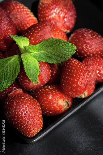 Healthy and fresh strawberries in bowl with mint