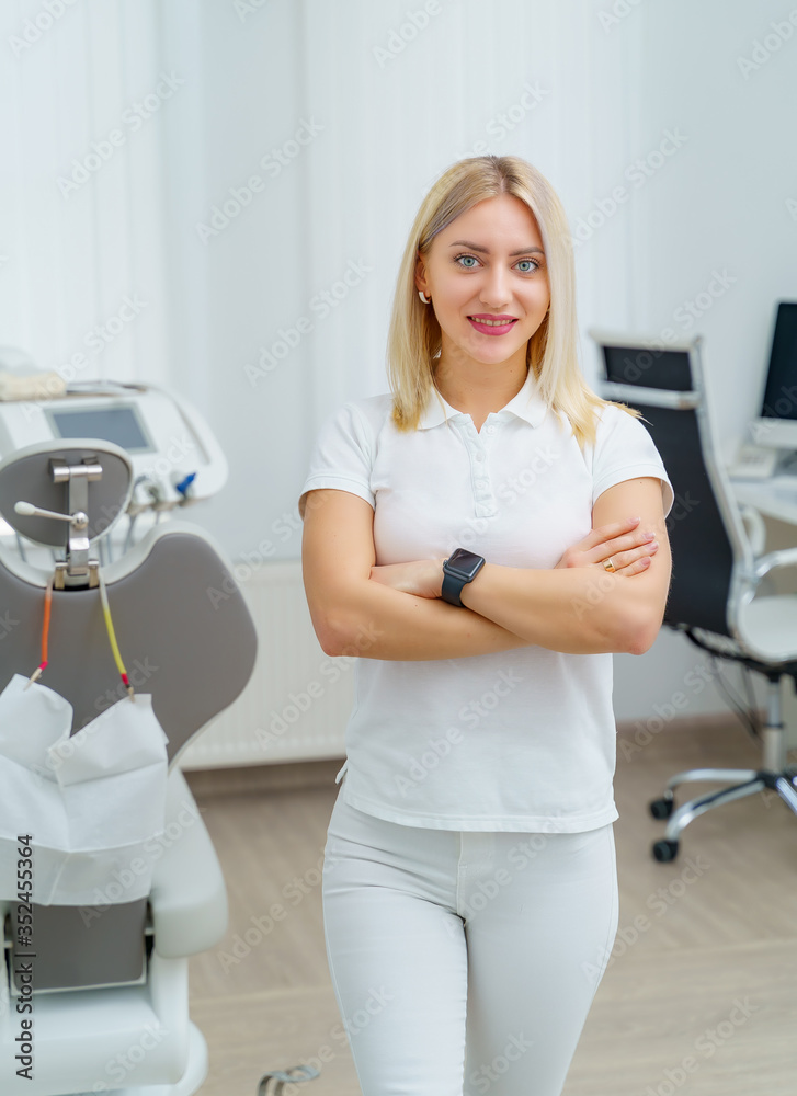 Portrait of a beautiful woman dentist looking at camera in a dentist office. Stomatologist in white uniform. Portrait of a beautiful woman dentist looking at camera in a dentist office. Stomatologist in white uniform.