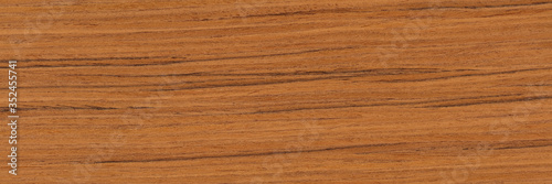 Natural teak veneer background in attractive brown color. Natural wood texture, pattern of a long veneer sheet, plank.