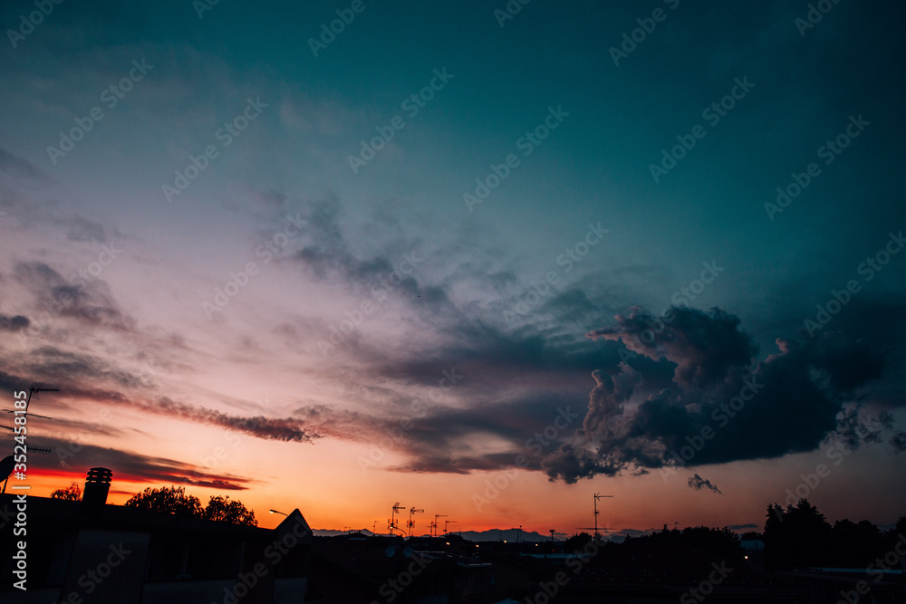 Warm and blue sunset with clouds and silhouette