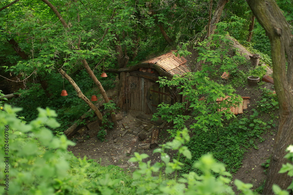Obraz premium A fabulous wooden house in a ravine. Fairytale landscapes. Children's recreation area. House of sorcerers