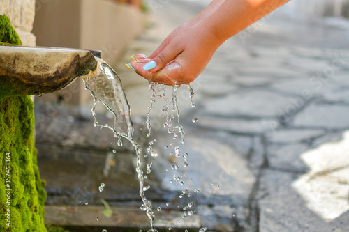 Washing hands in fresh, cold, potable source water on a mountain, Drinking Spring, Wooden Pipe of Fresh Potable, Unpolluted, Natural Spring Water