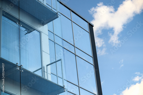 Glass building with sky and clouds reflection in windows