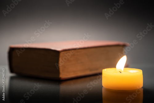 Old book and yellow candle.