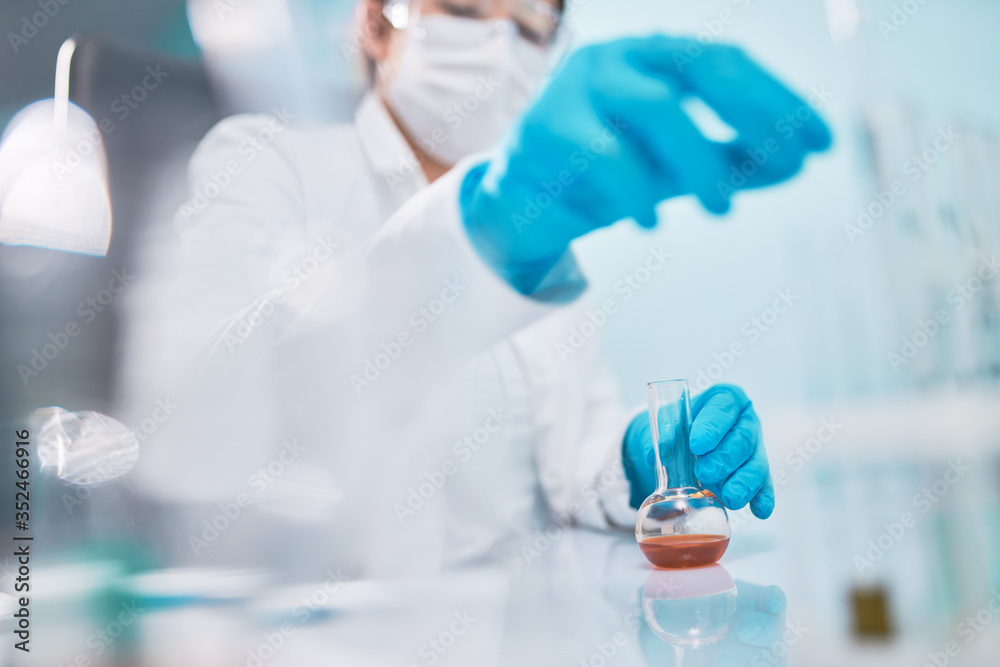 Woman lab technician with flask, blurred background. Woman lab technician with flask, blurred background.