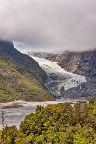 View of a glacier nestled in the greenery of the South Island of New Zealand