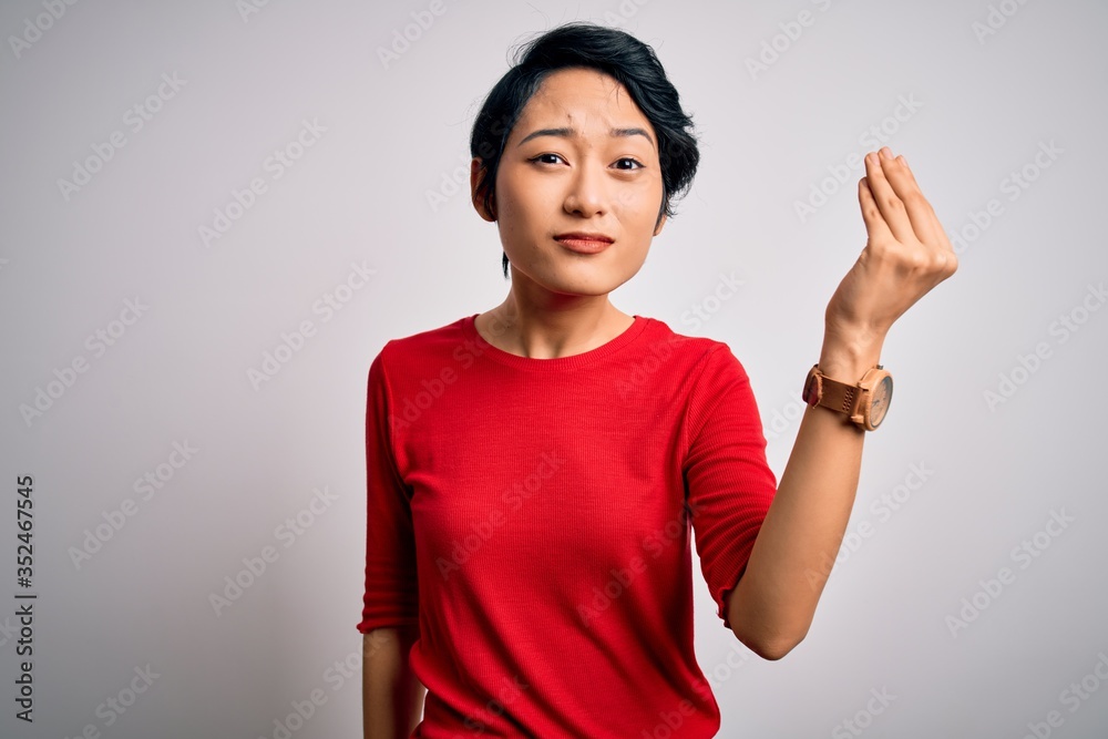 Young beautiful asian girl wearing casual red t-shirt standing over isolated white background Doing Italian gesture with hand and fingers confident expression Young beautiful asian girl wearing casual red t-shirt standing over isolated white background Doing Italian gesture with hand and fingers confident expression