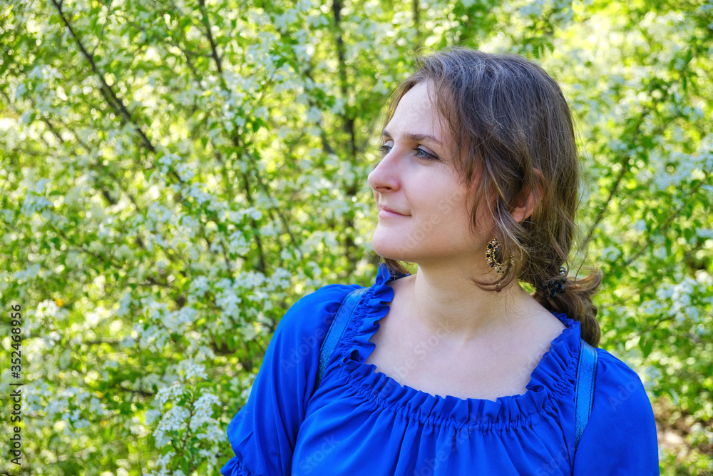 Portrait woman in cherry flowers on a green background Portrait woman in cherry flowers on a green background