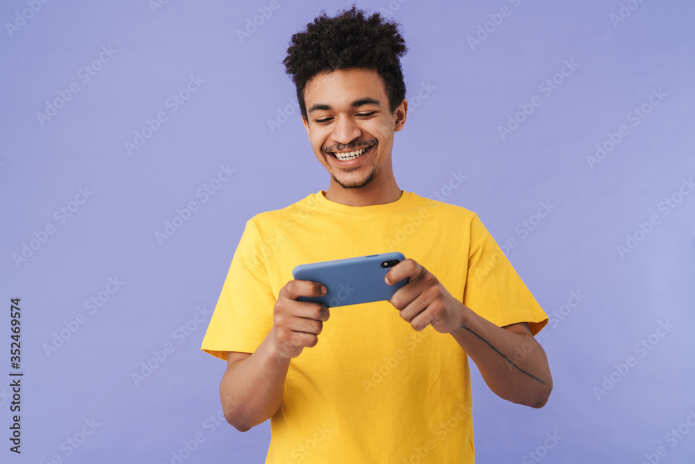 Photo of african american man playing video game on smartphone Photo of african american man playing video game on smartphone
