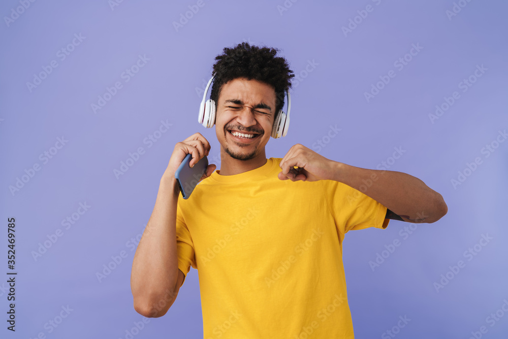 Photo of african american man using cellphone and wireless headphones Photo of african american man using cellphone and wireless headphones
