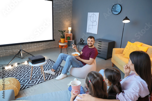 Foto Young family watching movie at home