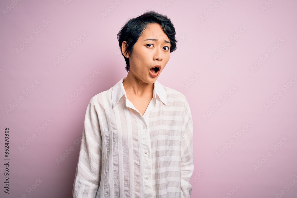 Young beautiful asian girl wearing casual shirt standing over isolated pink background In shock face, looking skeptical and sarcastic, surprised with open mouth Young beautiful asian girl wearing casual shirt standing over isolated pink background In shock face, looking skeptical and sarcastic, surprised with open mouth