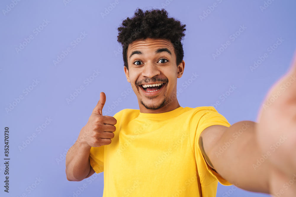 Photo of african american man taking selfie photo and showing thumb up Photo of african american man taking selfie photo and showing thumb up