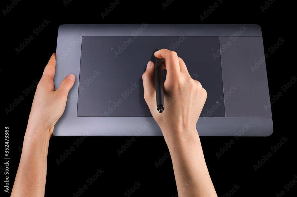 Hand holding digital graphic pen and drawing graphic tablet isolated on black