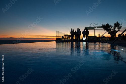 business people silhouette backlight in swimming pool at sunset with space to write