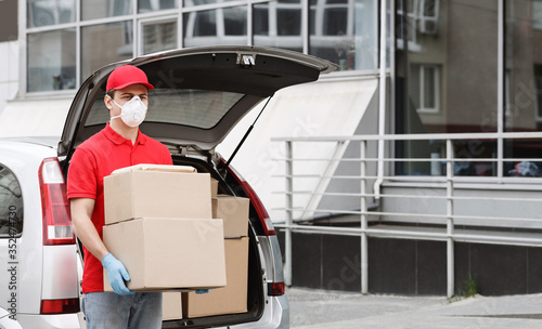 Home delivery during panic of coronavirus concept. Courier with boxes near the car