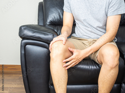 Man touching knee, having knee pain - close up