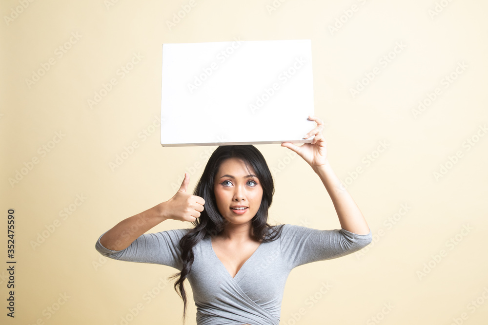 Young Asian woman show thumbs up with white blank sign. Young Asian woman show thumbs up with white blank sign.